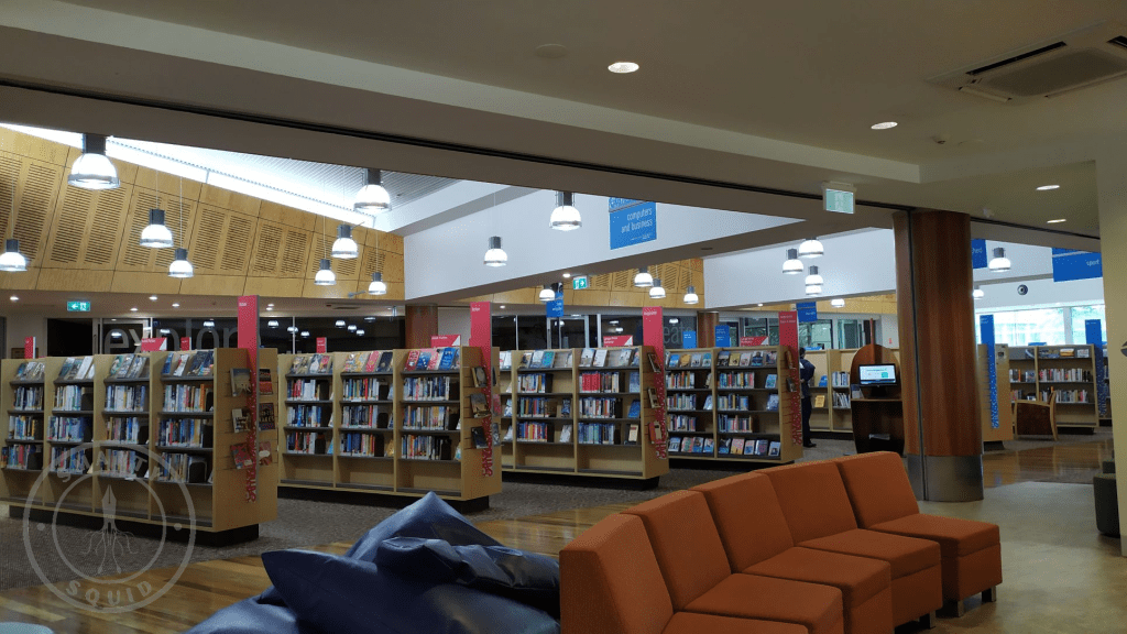 books on shelves. orange sofa on the forefront of the image