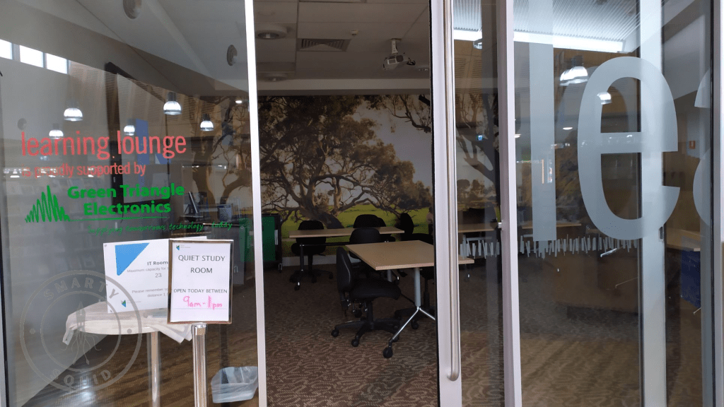 clear sliding doors leading to a room with desk and chairs